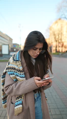 young woman using smartphone on city street