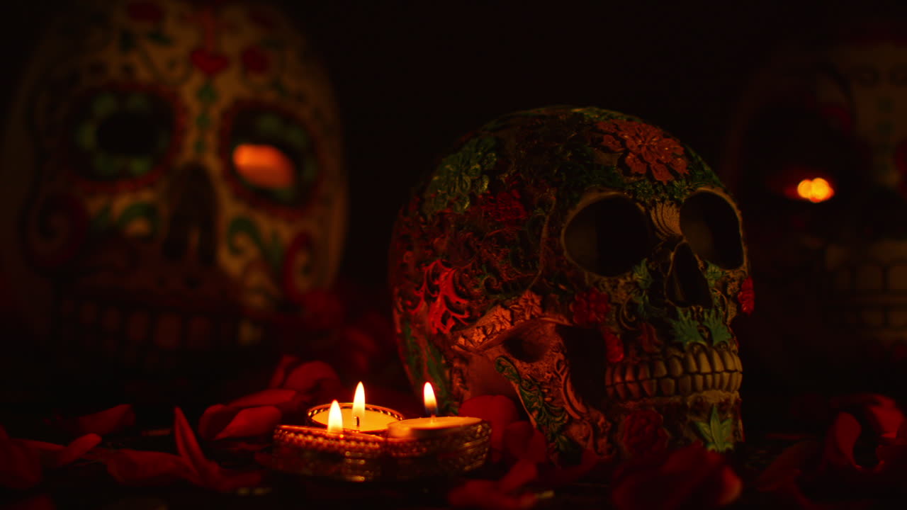 불과 꽃잎으로 둘러싸인 장식된 두개골의 정체물이 멕시코의 dia de los muertos (죽음의 날) 을 축하하고 있습니다.