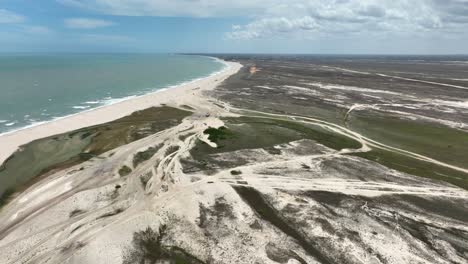jericoacoara beach showing vast sand dunes, coastline, and ocean waves, aerial view