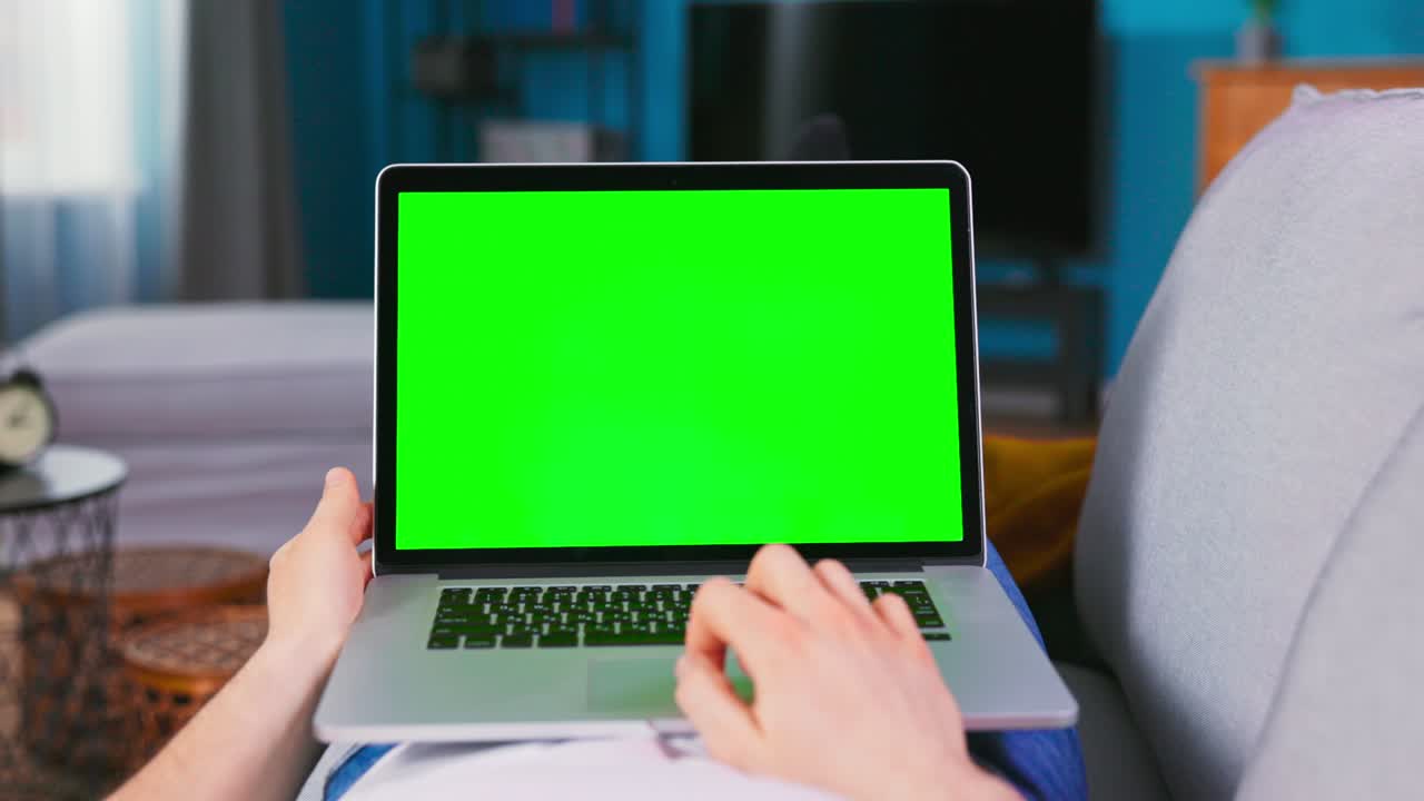 Close up of male Hand is using laptop touch pad. Modern Personal Computer with Mock-up Green Screen Display
