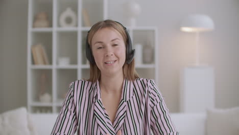 active-and-positive-woman-is-talking-to-camera-by-headphones-portrait-of-female-blogger-and-webinar-host