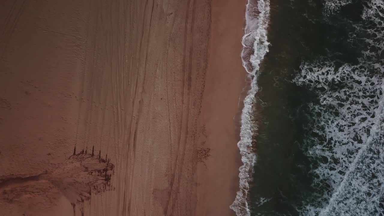 drone lento acercándose hacia la playa con olas y océano en kauai, hawaii al atardecer