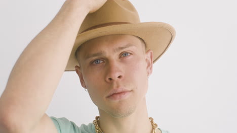 portrait of young man putting a hat on, looks at front and then, moves his head 1