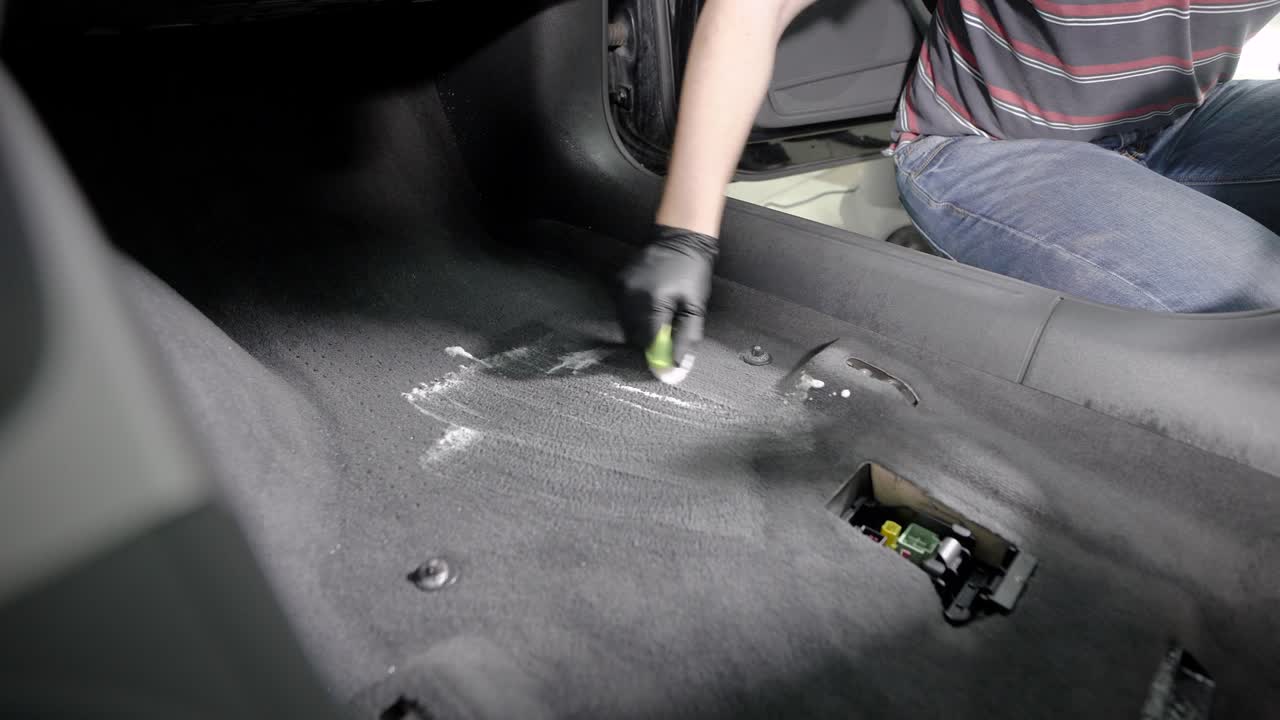 trabajador sin rostro en cuclillas y limpiando coches