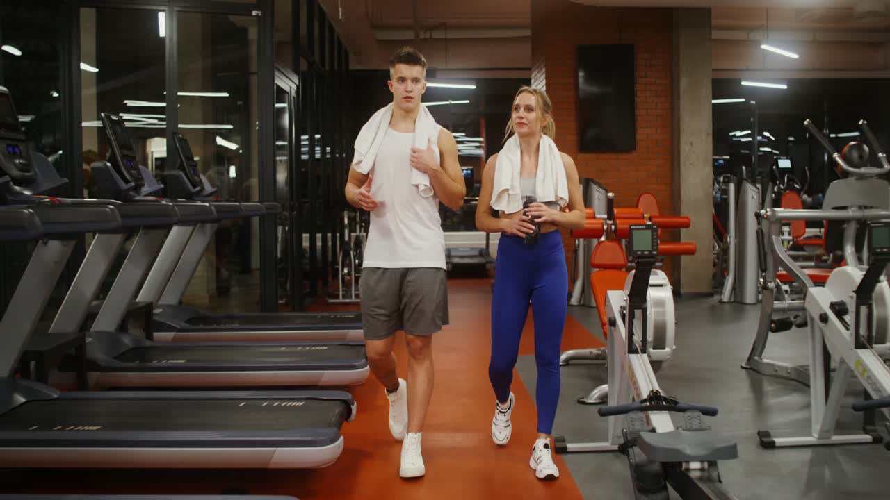 пара работает на беговой дорожке в тренажерном зале