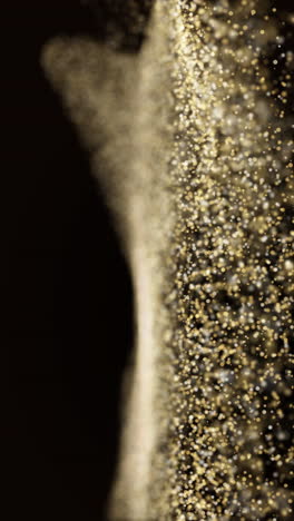 golden bright luxurious small particles move chaotically on a dark background. a blurred glow of gold. looped animation. vertical video.