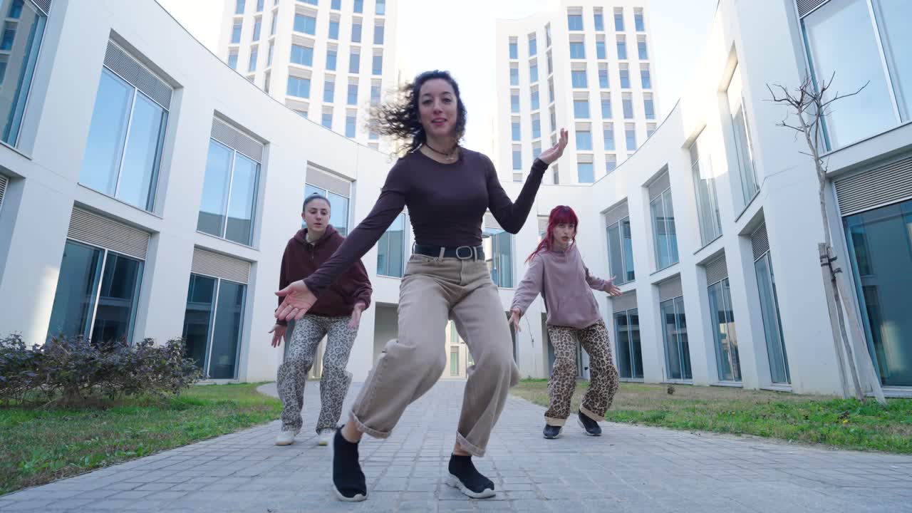 Young urban dancers performing energetic routine outdoors