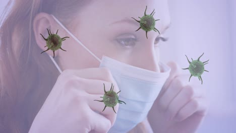 múltiples células de covid-19 que se mueven contra el primer plano de una mujer caucásica que usa una máscara facial