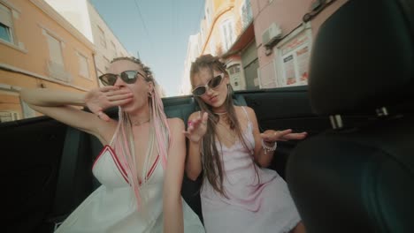 two young women enjoying a road trip in a convertible