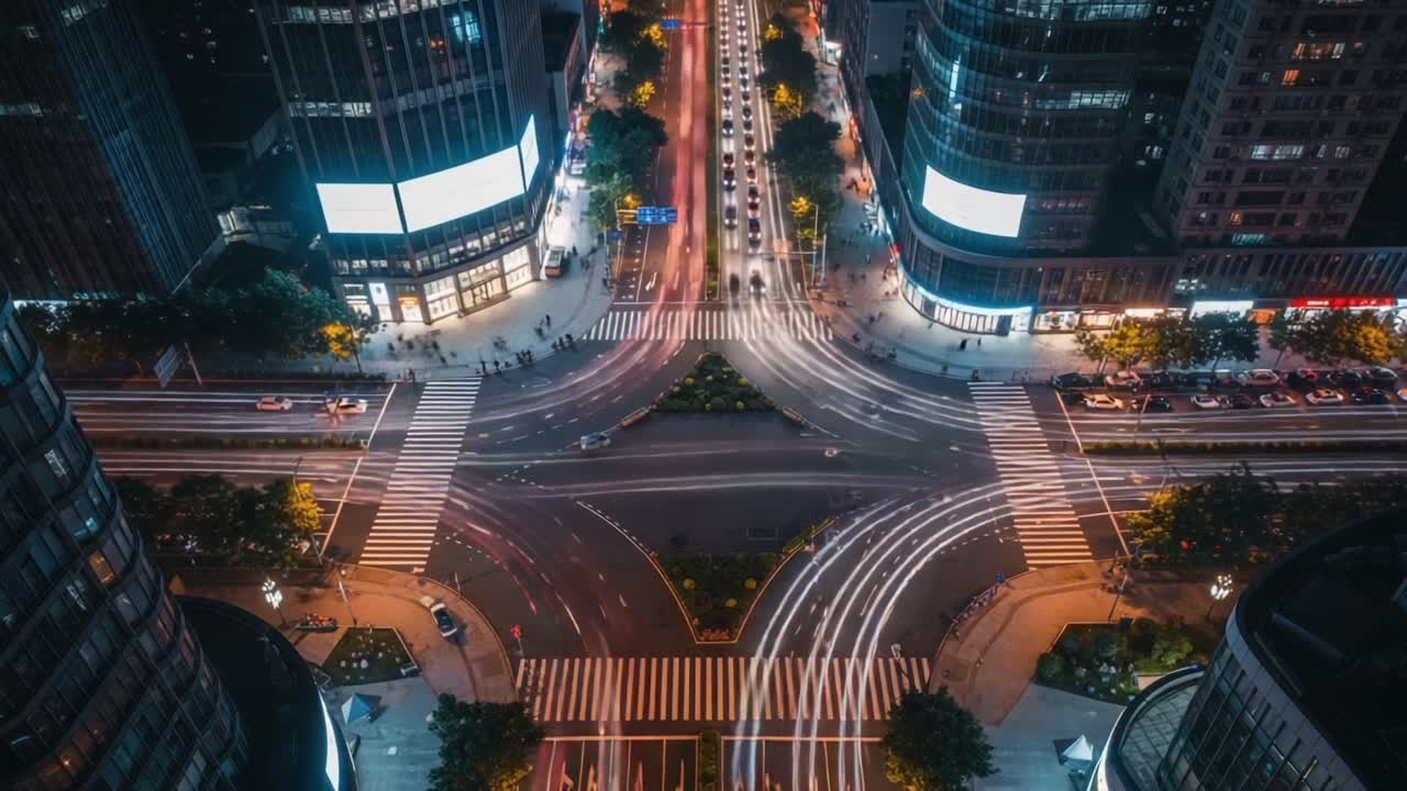Aerial View of Busy Urban Intersection at Night with Dynamic Light Trails from Moving Vehicles and Pedestrians in a Lively City Environment