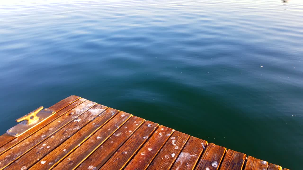 태양이 아침에 화려한 초점과 색상으로 부두의 일부를 우아하게 할 때 갈매기가 멀리서 들릴 수 있습니다.