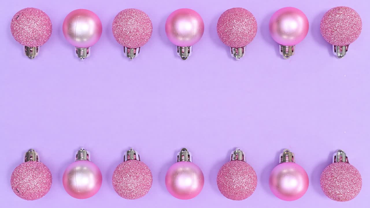 Ornamenti natalizi monocromatici rosa pastello appaiono in alto e in basso su tema viola. Stop motion