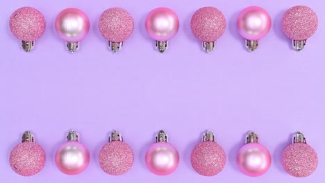 los adornos de navidad monocromáticos de color rosa pastel aparecen en la parte superior e inferior del tema púrpura.
