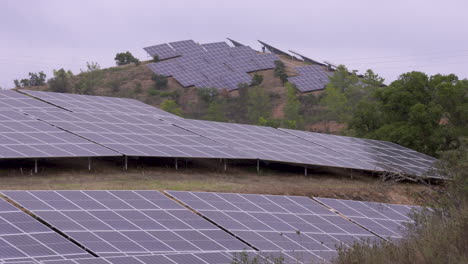 energía sostenible en la naturaleza en la ladera de una montaña llena de paneles solares frente al sol