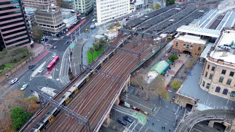 Querformatansicht-Des-Zuges,-Der-Den-Bahnsteig-Des-Hauptbahnhofs-über-Eine-Viel-Befahrene-Straßenbrücke-In-Sydney,-Haymarket,-Surry-Hills,-Australien,-Verlässt,-Transportreisen