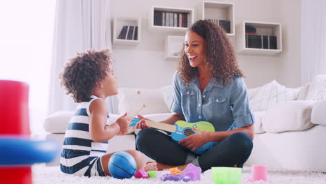 Young-black-girl-playing-xylophone-with-mum-in-sitting-room