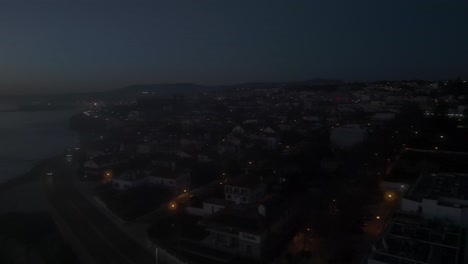 Aéreo,-Seguimiento,-Disparo-De-Drone-De-Marginal-En-La-Costa-De-Estoril,-En-La-Noche-En-Lisboa,-Portugal