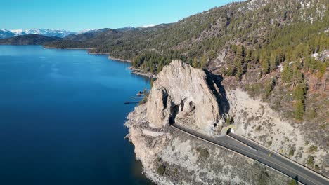 Aerial-orbit-view-of-Cave-Rock-tunnel-and-mountain-lake-landscape,-Lake-Tahoe,-California