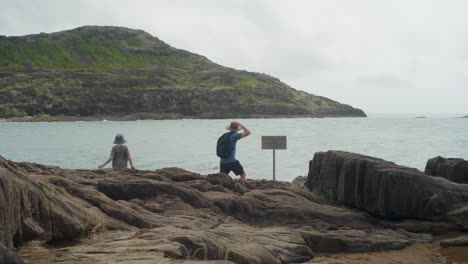 the sign at the northernmost point of australia, known as pajinka, or the tip, in cape york. a man and his son reach the sign. clip 2