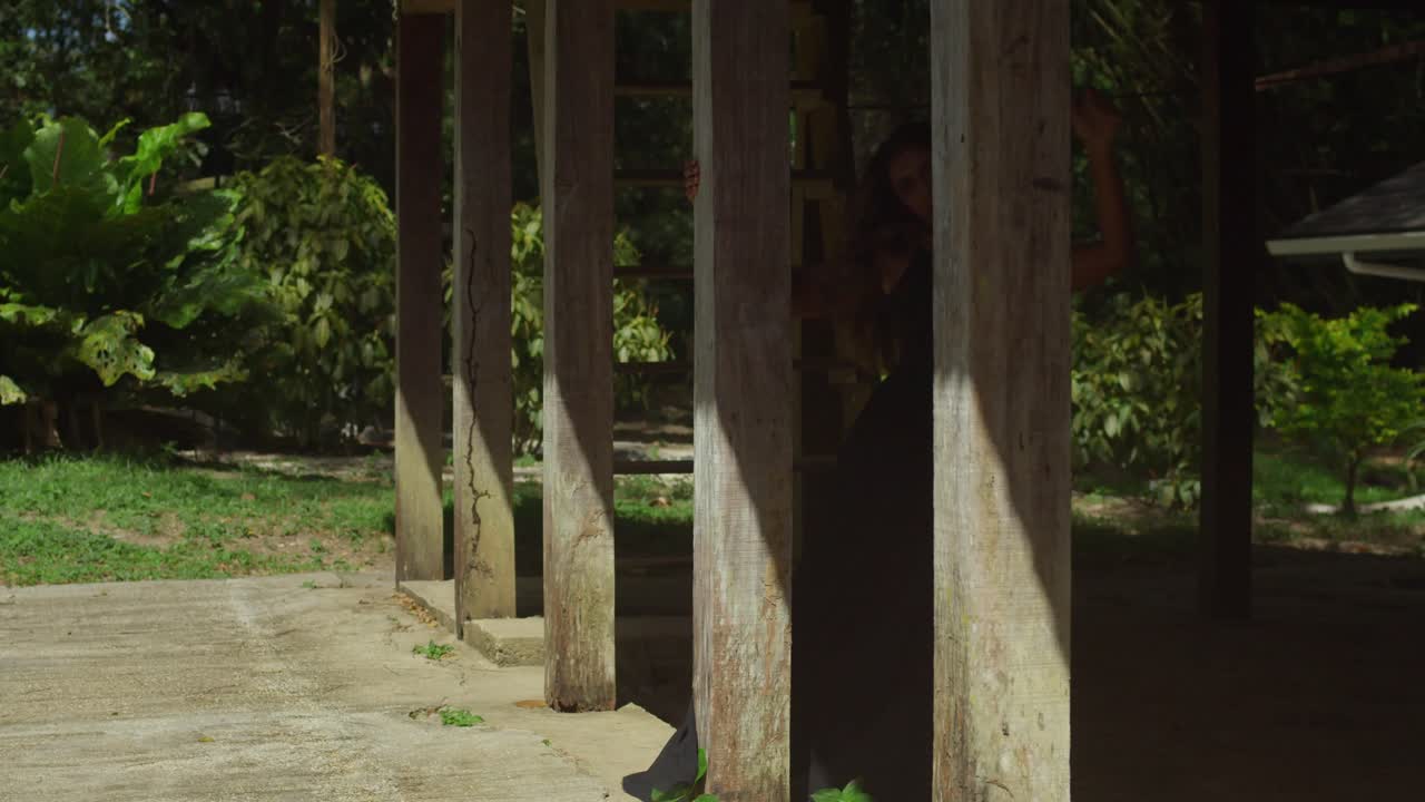 Clad in a black dress, a young girl enjoys the tranquility of the river.