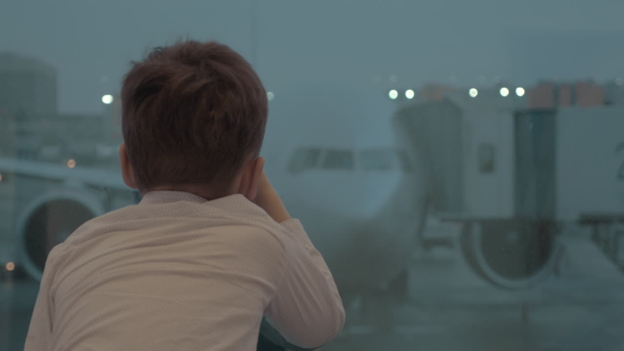 비행기를 기다리는 동안 비행기를 바라보는 호기심 많은 소년