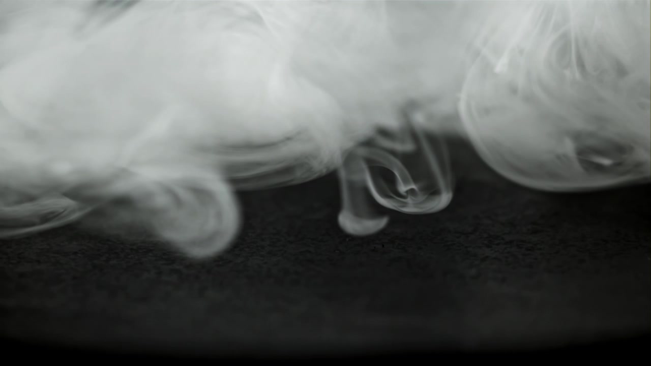 Dense White Smoke Flowing and Swirling on a Dark Surface