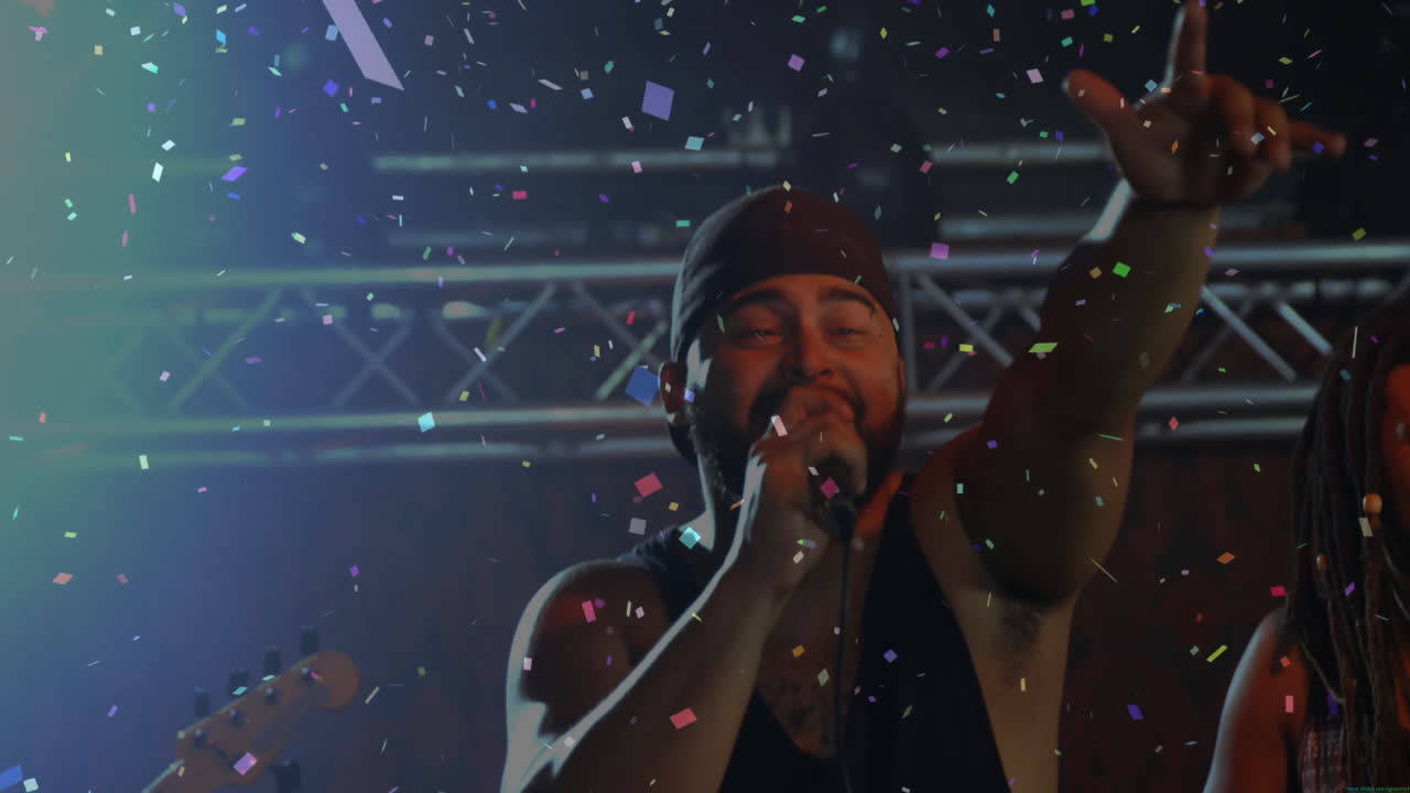 Bandmates performing on music stage, highlighting lead singer with floating confetti and lighting