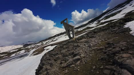 Schneller-FPV-Flug-Aus-Der-Luft-über-Die-Schneebedeckte-Landschaft-In-Der-Nähe-Des-Grimselpasses-Und-360-Grad-Drehung-Um-Die-Skulptur