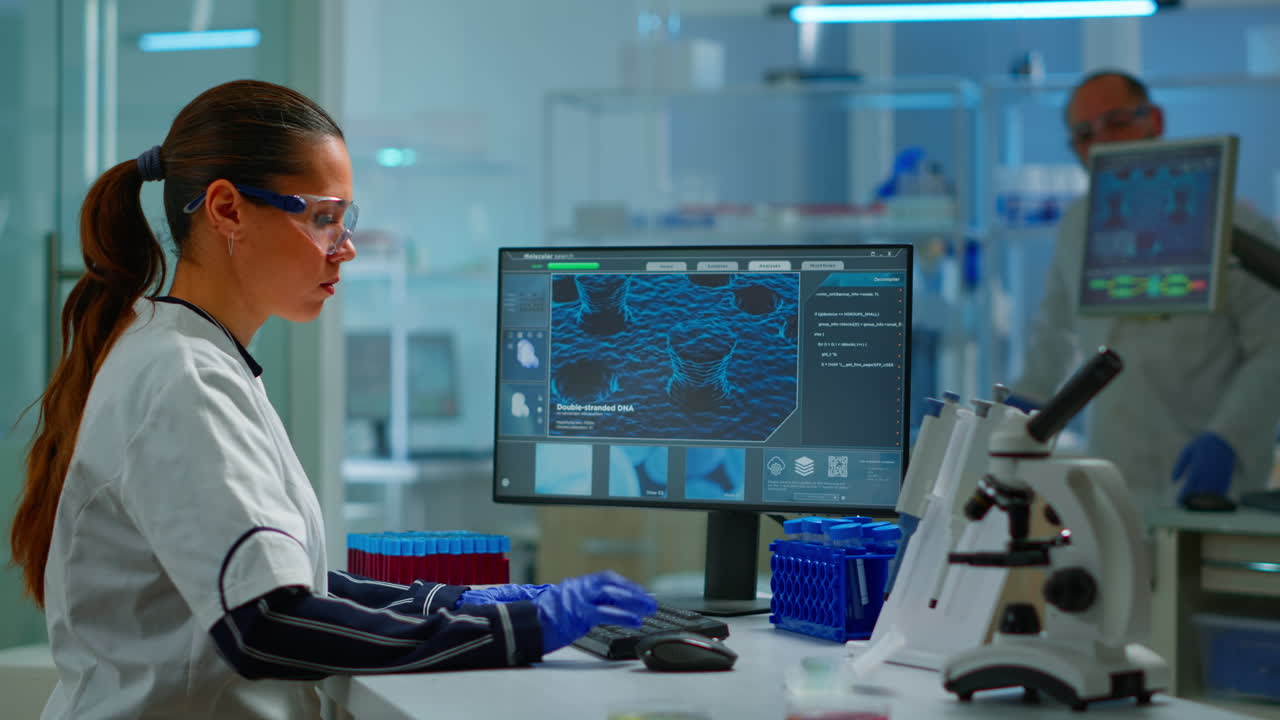 médico biólogo comprobando la información del adn escribiendo en la computadora