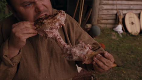 medieval man eating roasted meat