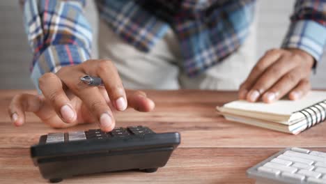 person calculating on calculator at desk