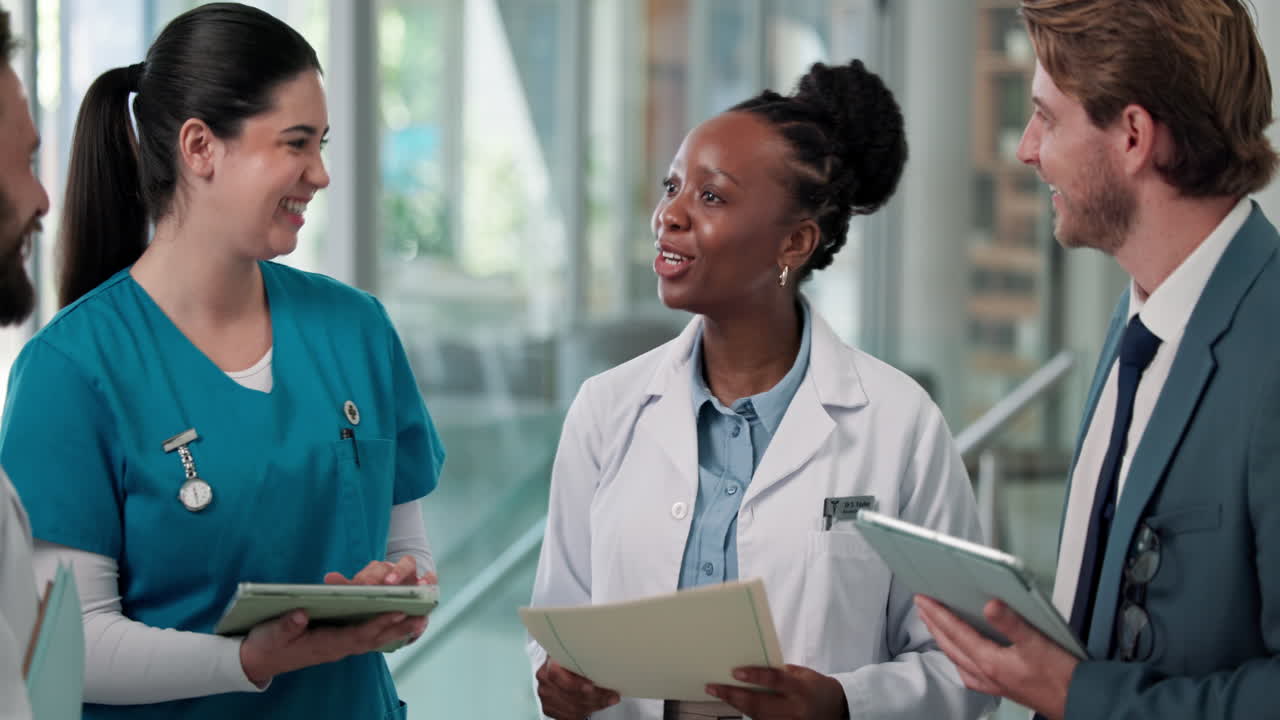 Smiling Medical Staff and Businessman Talking in a Modern Hospital