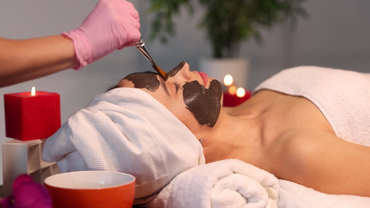 Woman Receiving a Facial Mask Treatment at a Spa