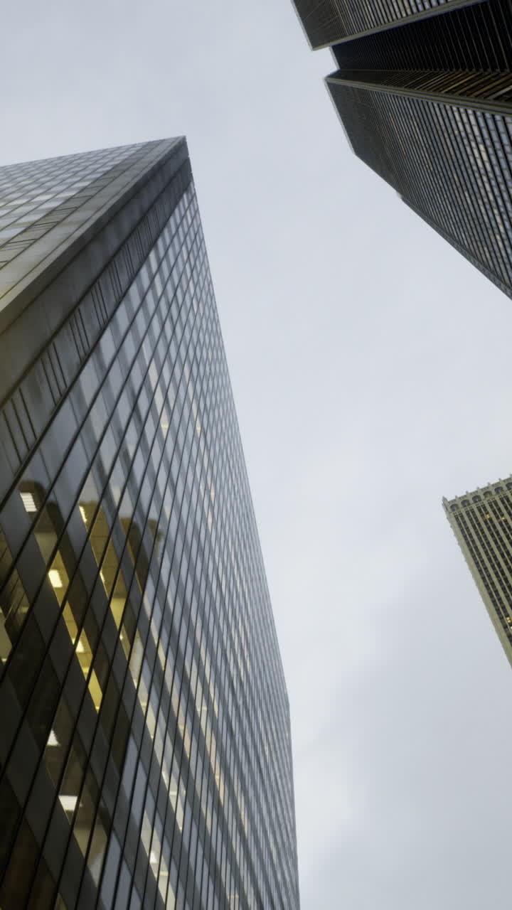 Skyscrapers rise majestically into a cloudy sky over a bustling city landscape