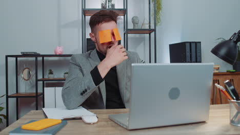 inefficient tired lazy businessman working sleeping on laptop computer with eyes stickers on face