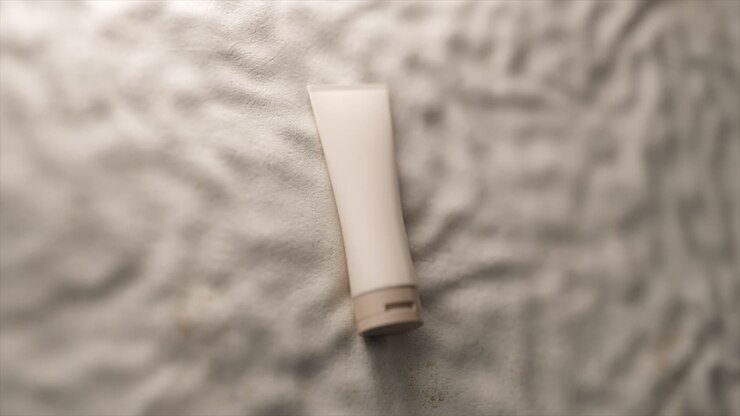 Tubetto di crema bianco su una superficie testurizzata