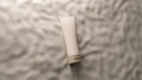 white tube of cream on a textured surface