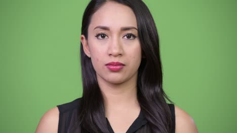 young beautiful asian businesswoman against green background