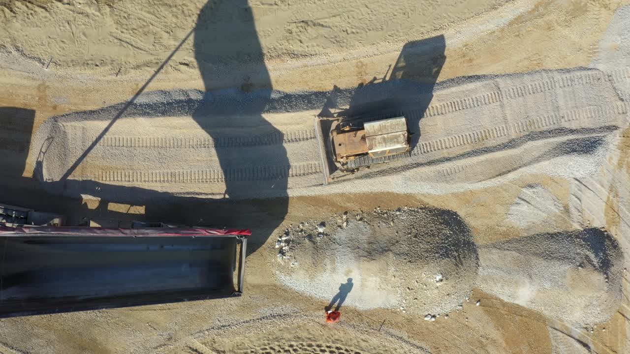 vista aérea en el camión de descarga está descargando grava del remolque sobre el sitio de construcción para la nueva rotonda de tráfico