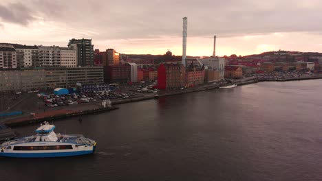 Aerial-drone-flight-over-smooth-waters-at-harbor-area-in-Gothenburg,-Sweden-at-sunset