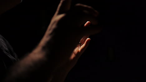close-up of a man's hands in the dark