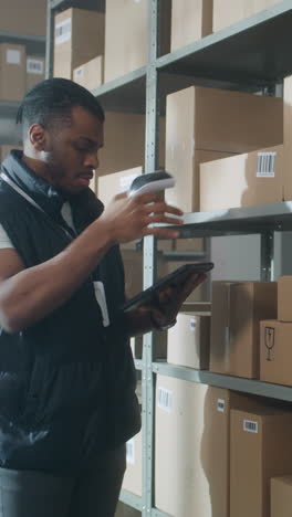 warehouse worker checking inventory with tablet and scanner