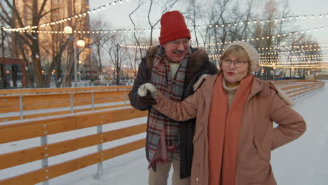 happy senior couple ice skating