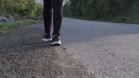 Toma-En-Cámara-Lenta-De-Pasos-De-Pie-De-Persona-Caminando-En-La-Calle-Lateral-Sobre-Asfalto