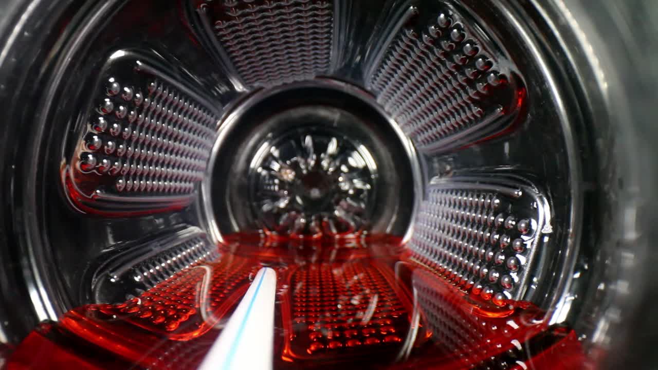 병을 열 때부터 시작하여 스포츠 음료나 주스 병 내부로 반쯤 들어가고 빨간색 액체 - 흰색 빨대가 보입니다.