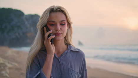 seashore girl talking mobile phone in evening closeup. beautiful sunset at sea