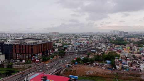 aerial shot of a sprawling city under cloudy sky with modern infrastructure buildings and storefronts.