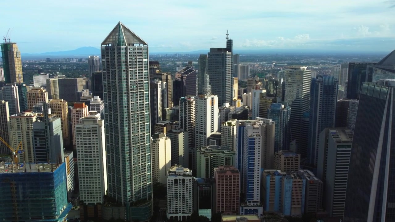 Ripresa panoramica con drone che circonda lo skyline della città di Makati, Manila, Filippine.