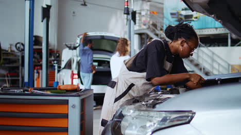 garage worker tightens car screws