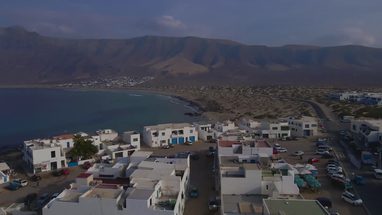 Aerial View of a Coastal Town with White Buildings and Sand Dunes
